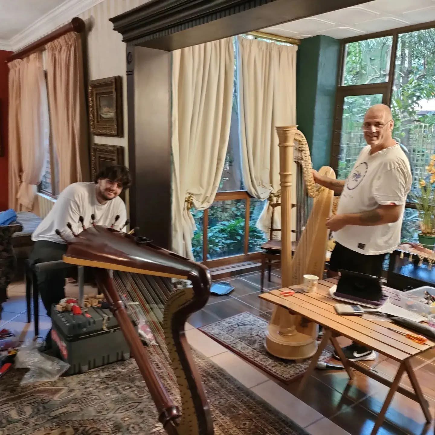 Harp technicians servicing a pedal harp and a concert harp